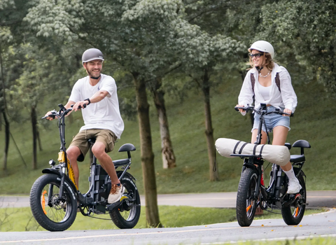 Two adults riding Romatlink Dolphin Folding Fat Tire Electric Bikes for an outing